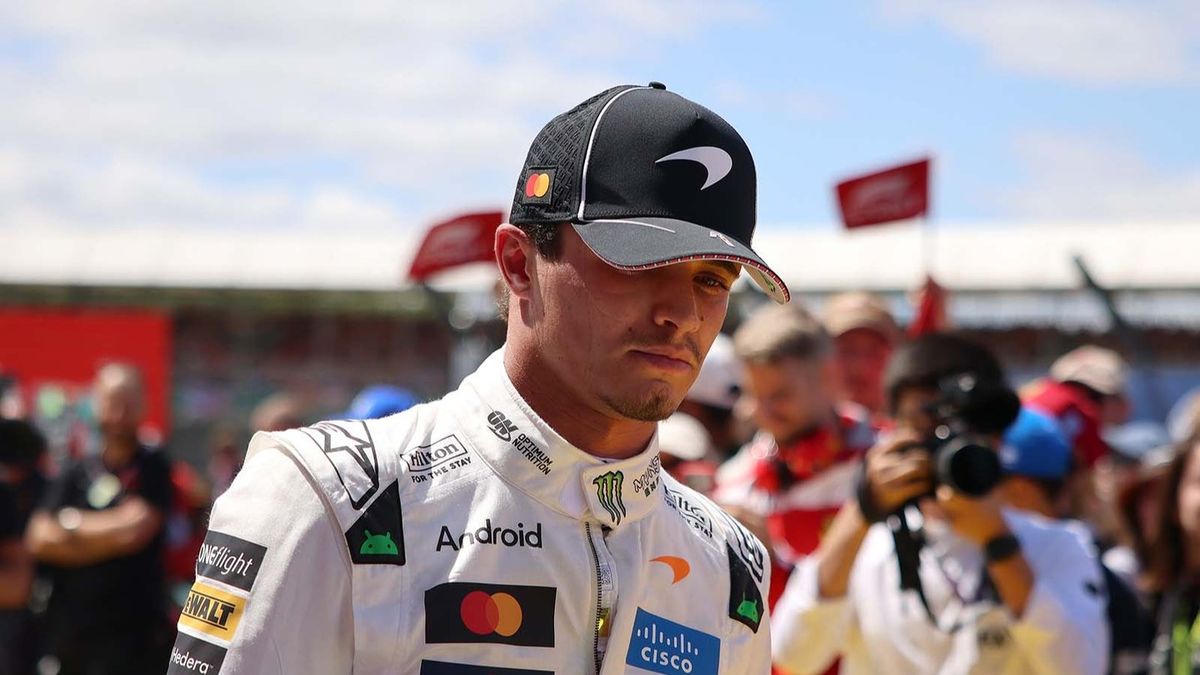 Lando Norris in reflective thought wearing McLaren gear.