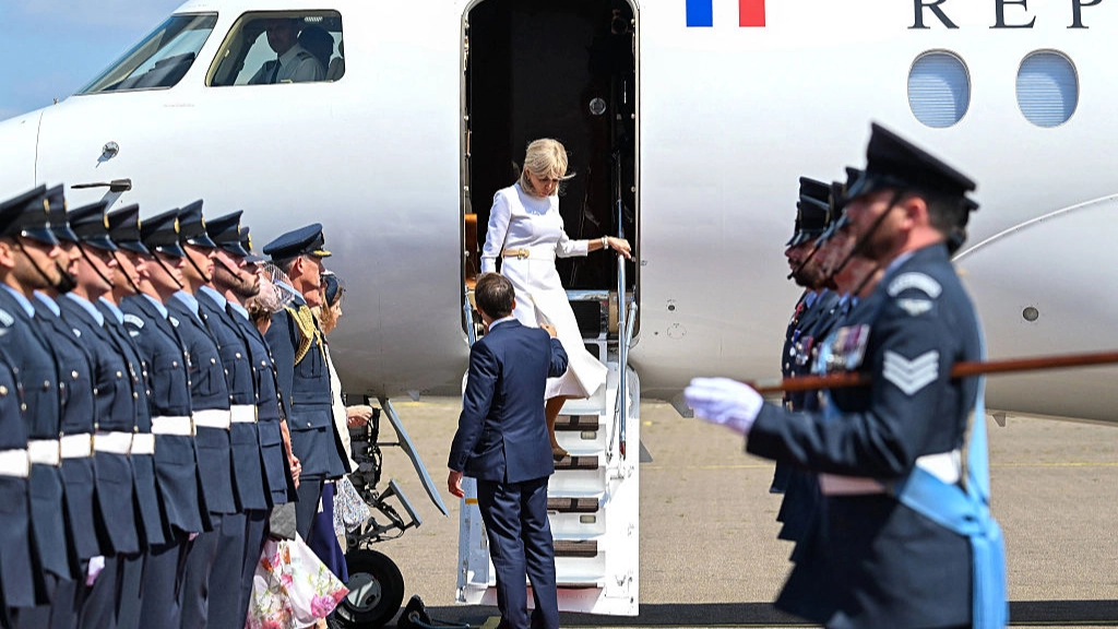 Awkward moment Emmanuel Macron left hanging by his wife as they arrive in UK for state visit