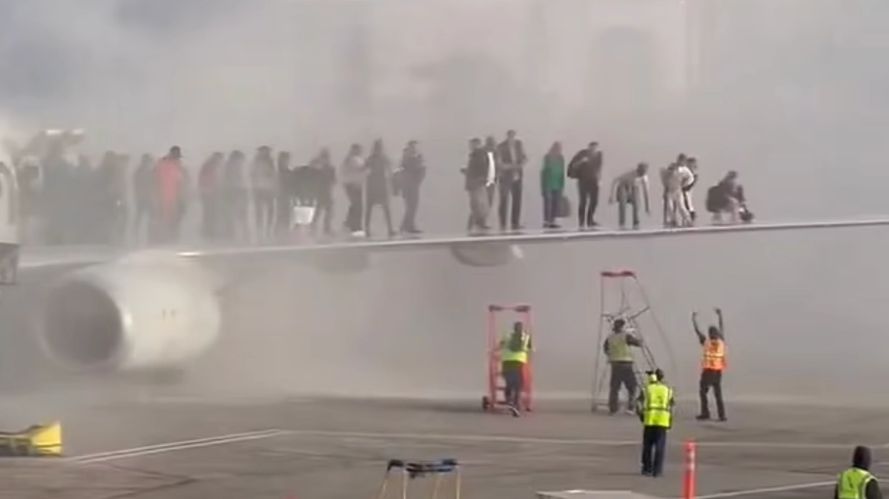 Passengers forced to escape onto wings as plane bursts into flames in terrifying scenes