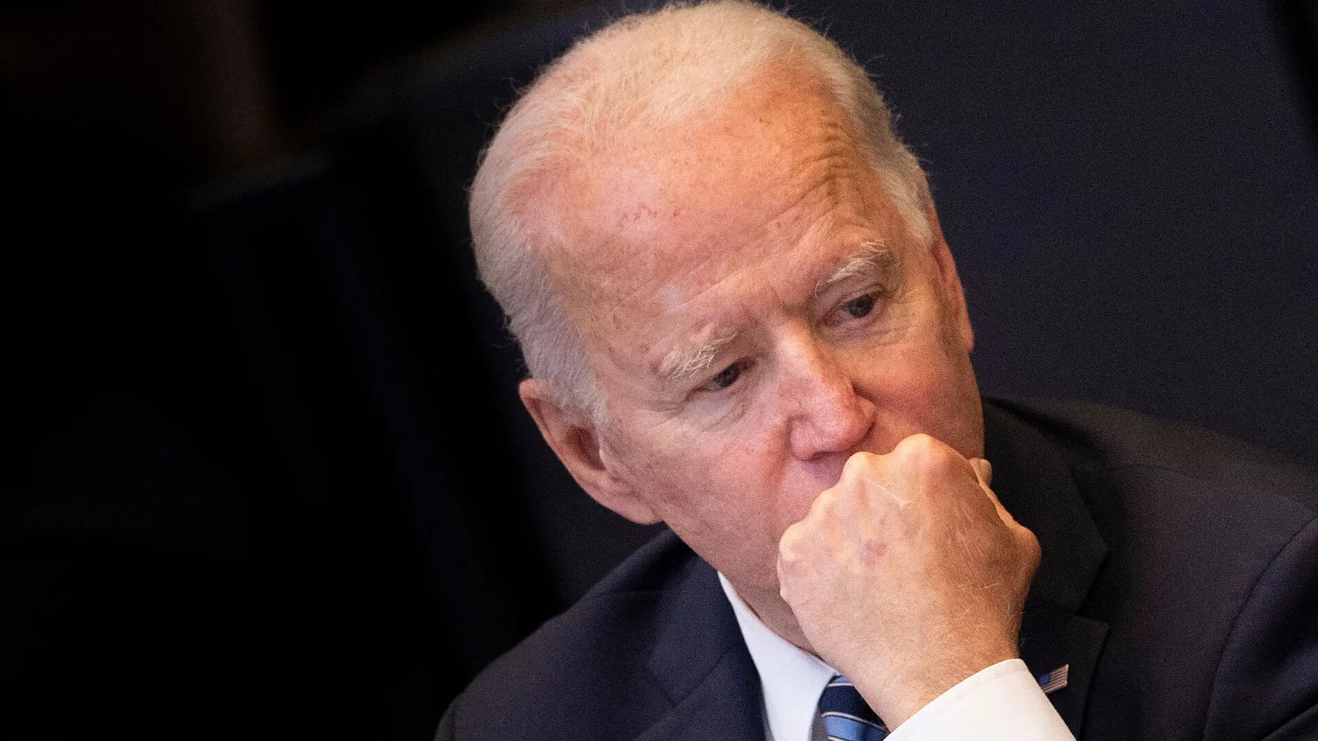 President Joe Biden sits with his fist to his chin. He looks stressed.