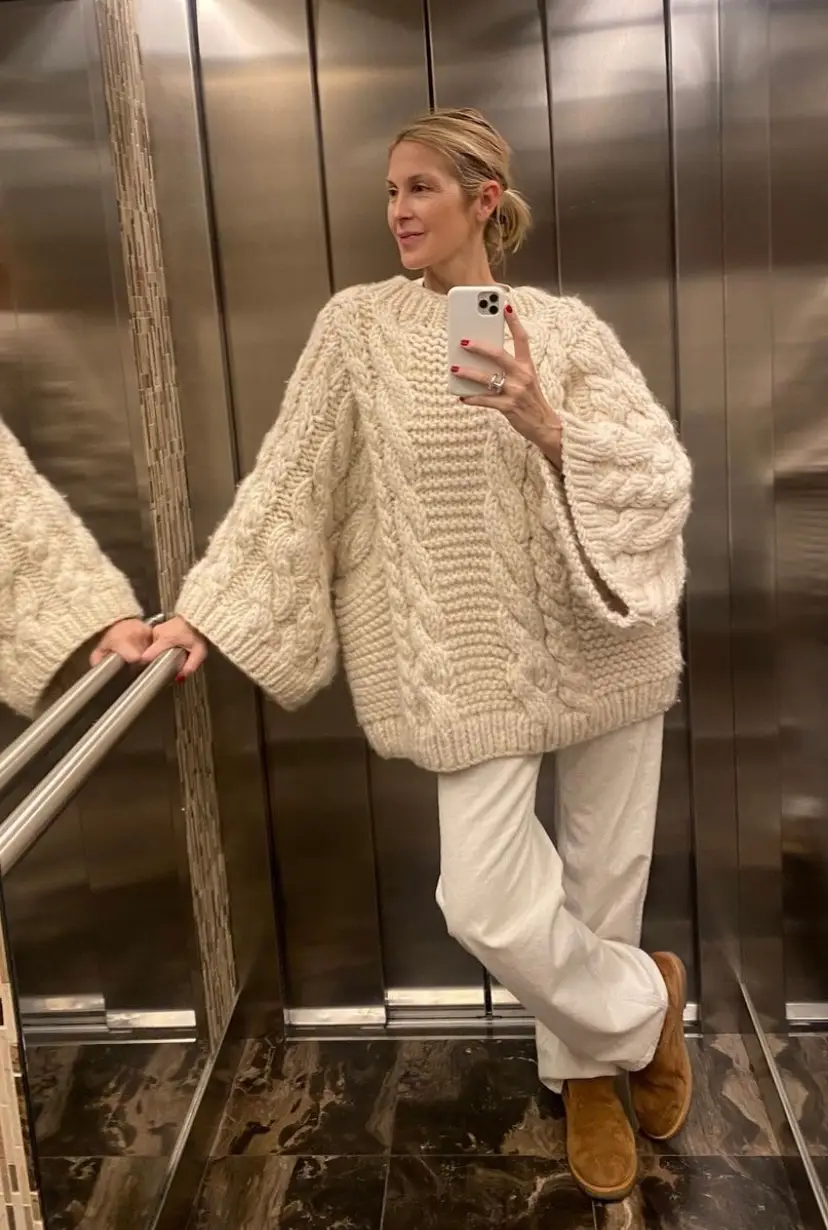 Kelly Rutherford wearing an all white outfit while taking an elevator selfie