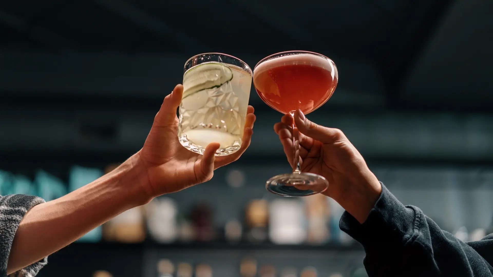 Close up of two people cheering cocktails in bar or disco club drinks and cocktails concept