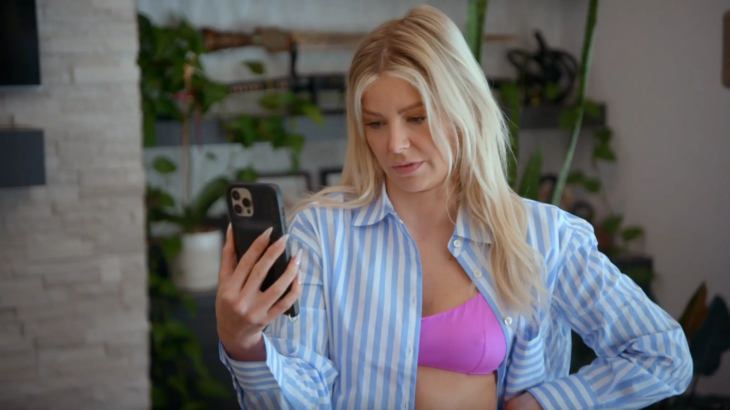 Ariana Maddix in her home on the phone wearing a stripped set