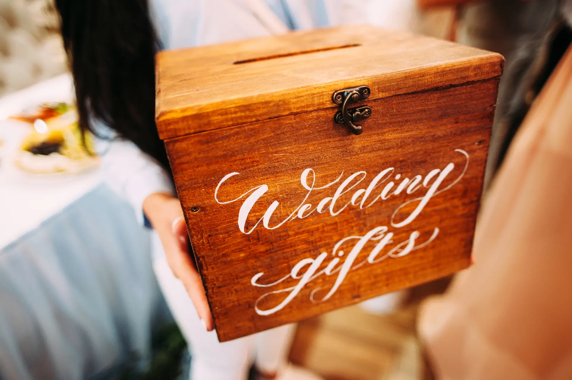 Wedding gifts. Bridesmaid holds wooden box with a sign.