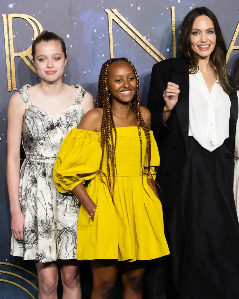 Zahara Jolie Pitt next to her mom Angelina and sister Shiloh on a red carpet in 2021