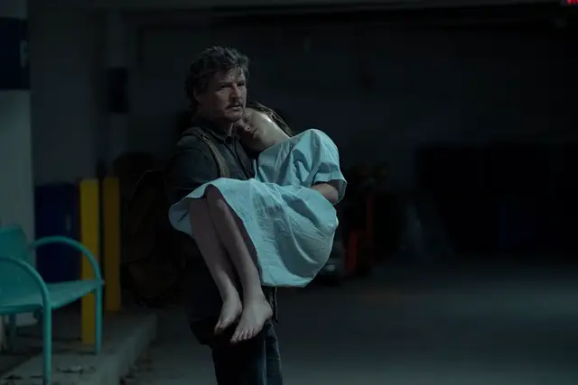 Pedro Pascal as Joel carrying Bella Ramsey as Ellie in The Last of Us season 1