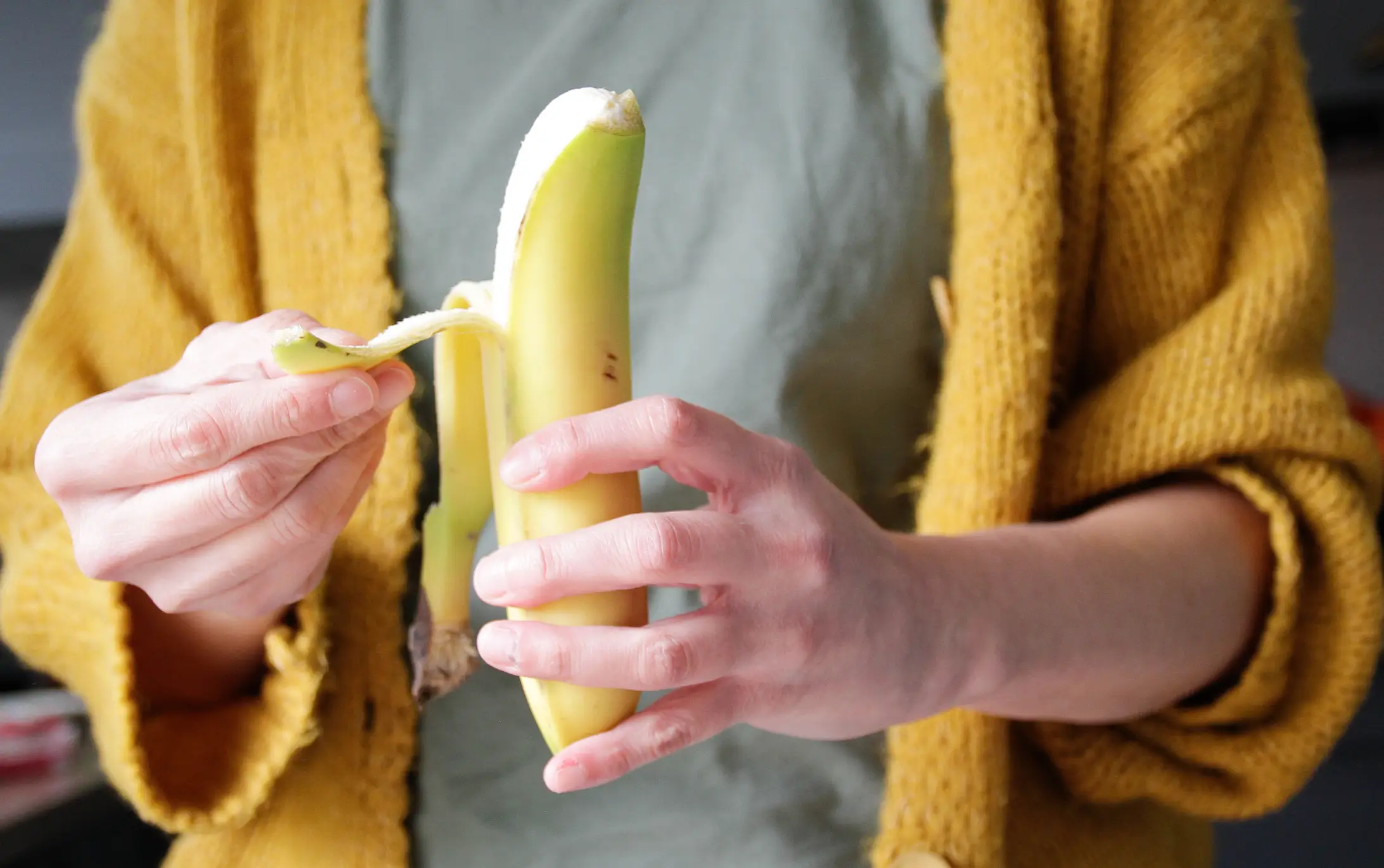A woman tucks into a banana - Kinga Krzeminska via Getty Images