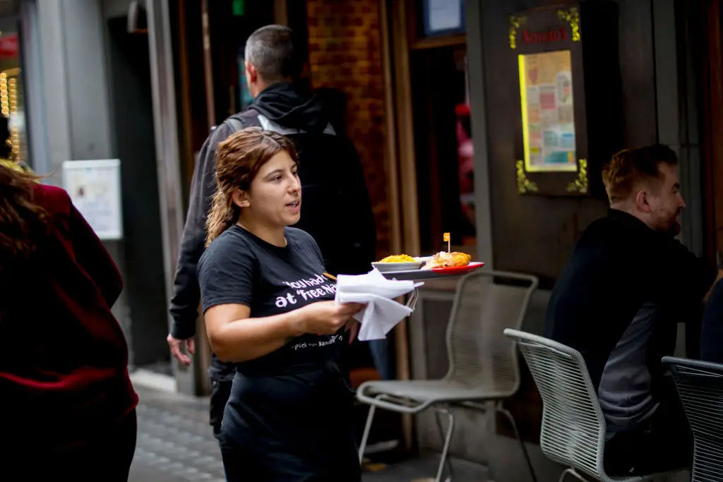 A Nando's waiter serving an order (TOLGA AKMEN/Getty Images)