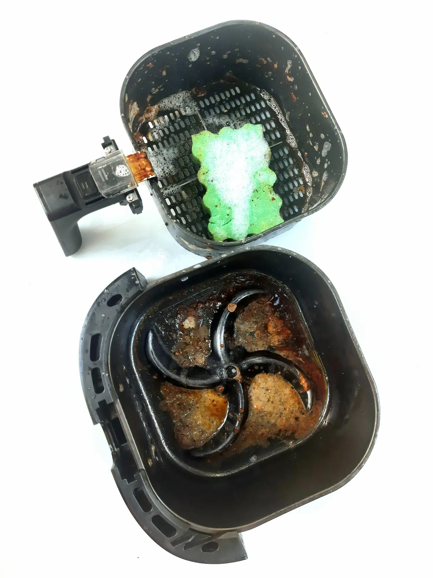 Cleaning an air fryer - Adisak Mitrprayoon via Getty Images