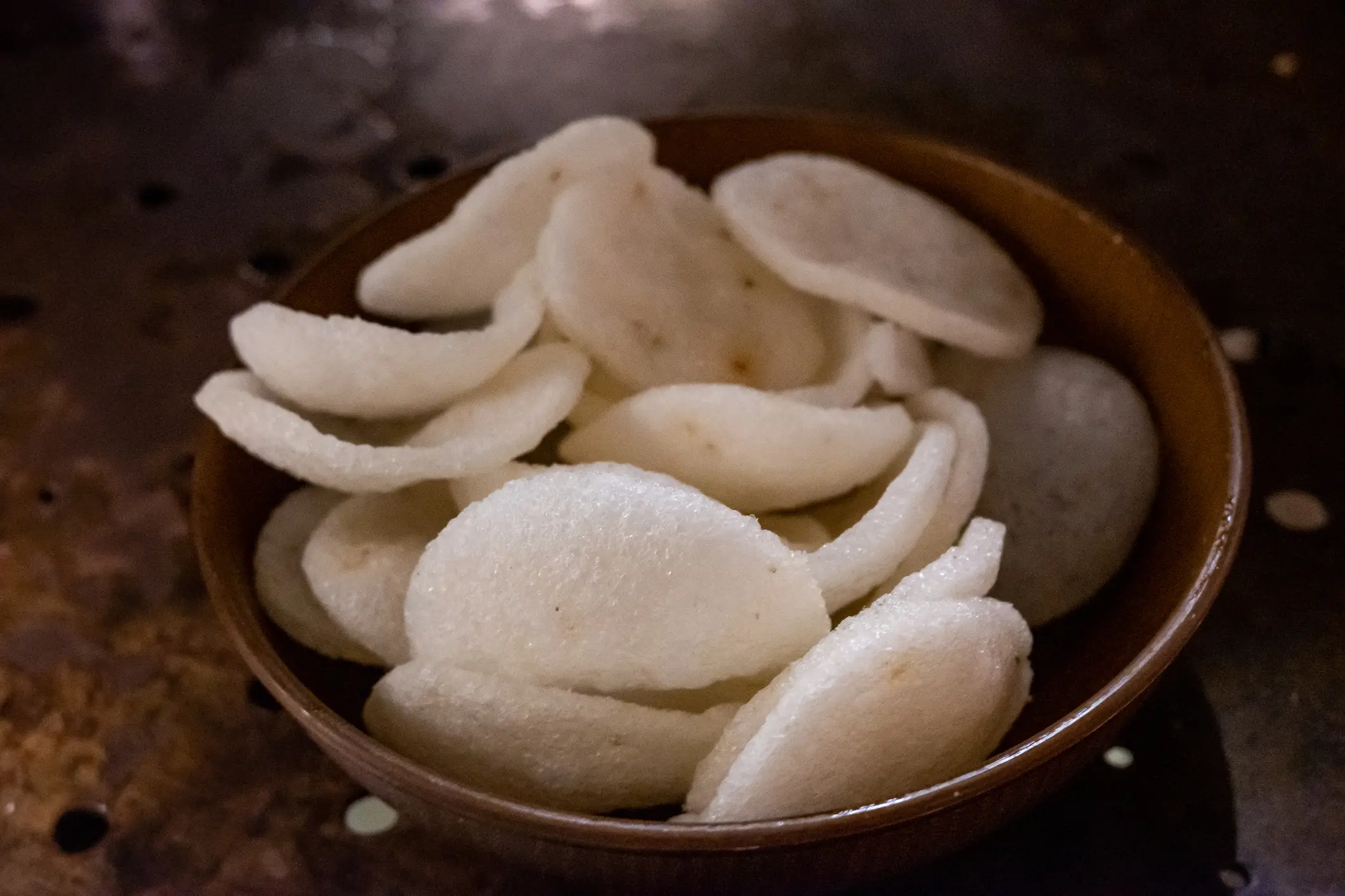 A close-up view of prawn crackers neatly arranged in a bowl (Sunphol Sorakul / Getty Images)