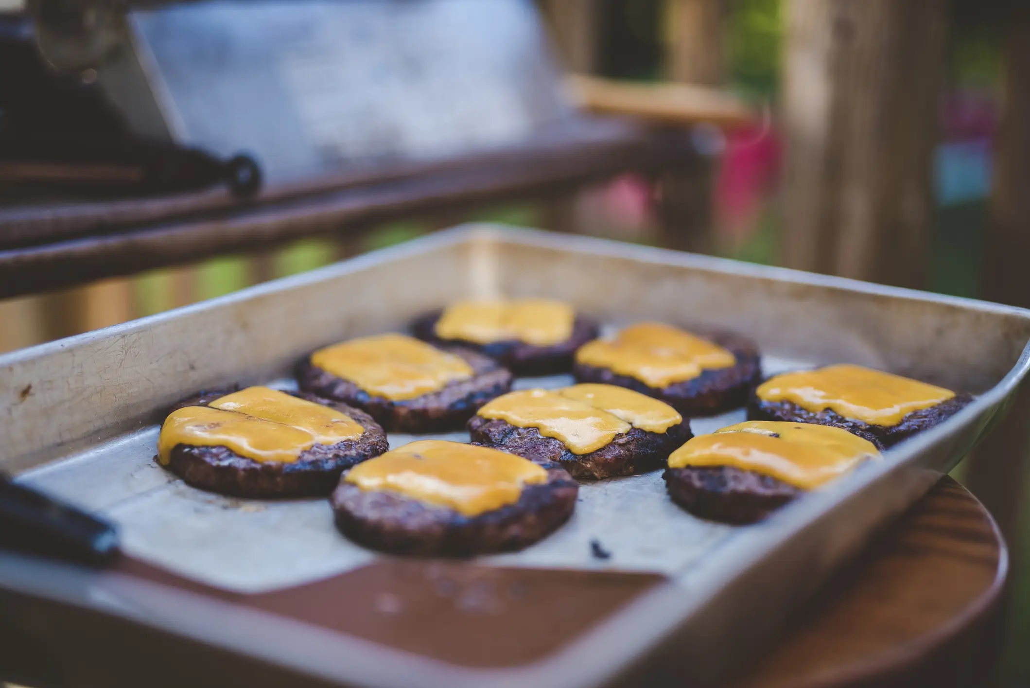 A tray of burgers with cheese - Wirestock via Getty Images