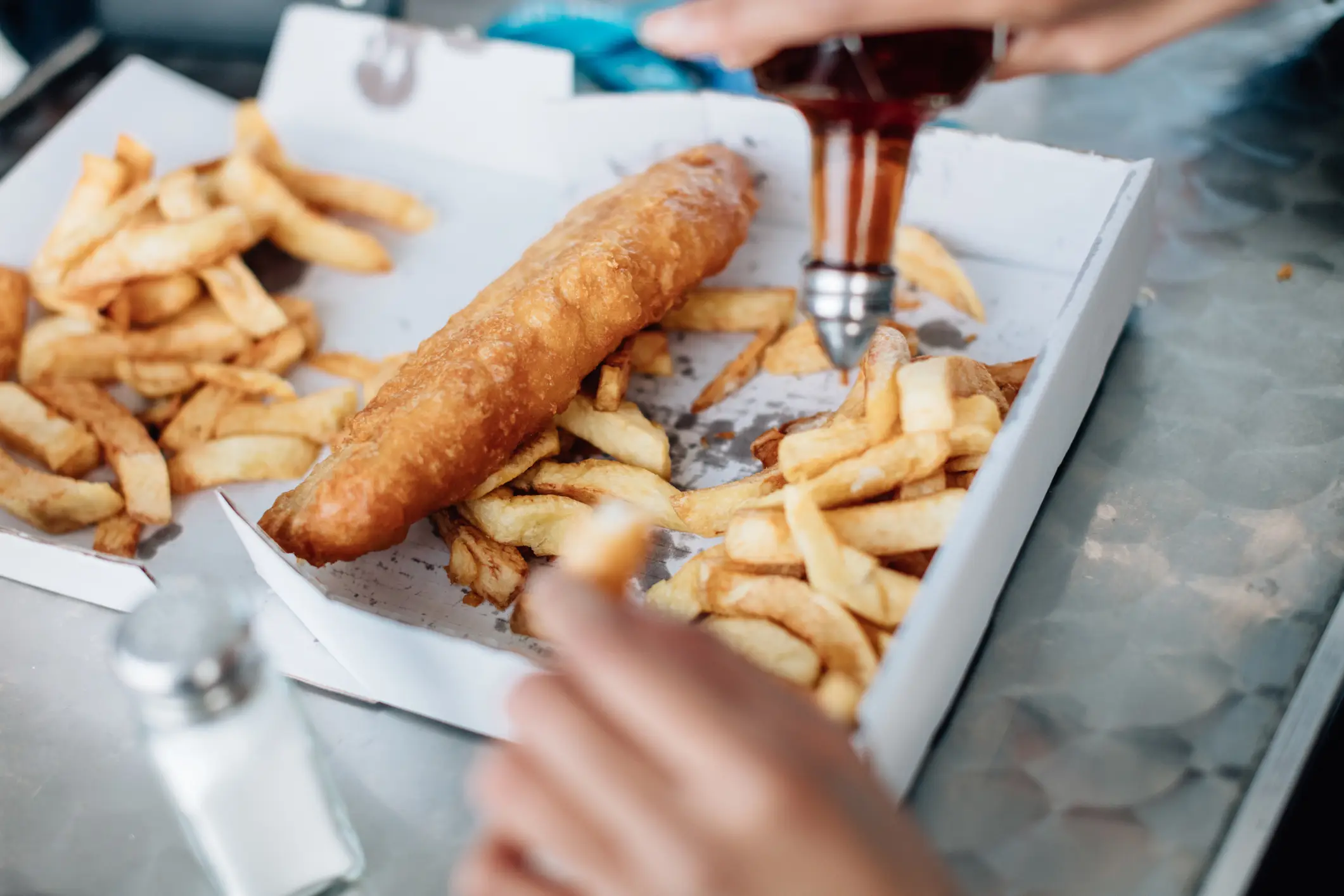 Pouring vinegar on fish and chips - Roo Lewis via Getty Images