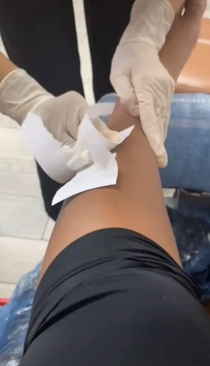 The beautician seemed to wax her leg using printing paper.