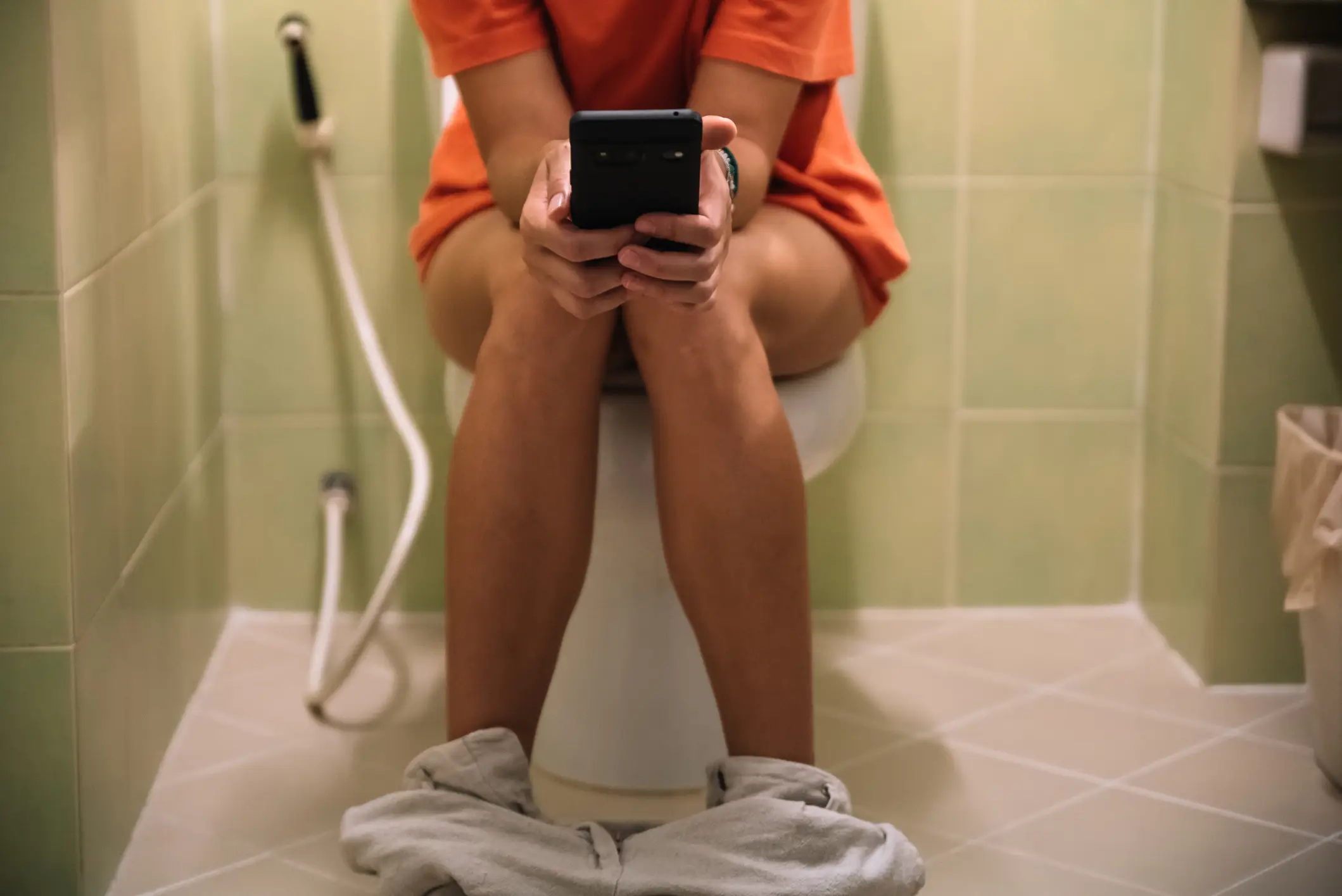 Most of us are guilty of scrolling on our phone for too long while on the toilet (Getty Stock Image)
