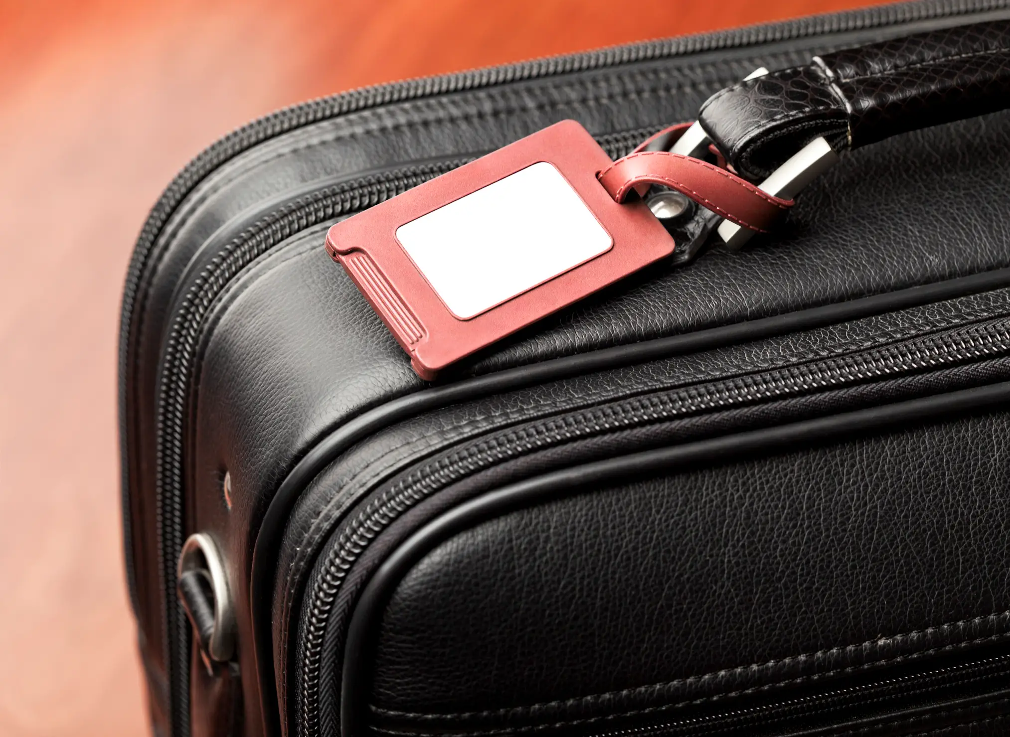 Think twice before fastening your luggage tag to your suitcase this summer! (greenp / Getty Images)