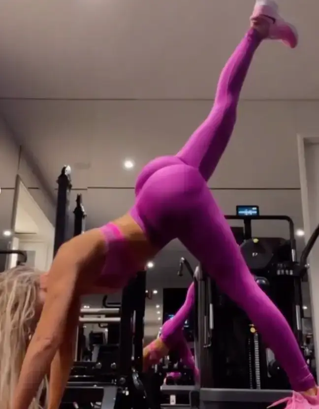 As she stretches her leg up, fans alleged they could see her 'butt implants'.
