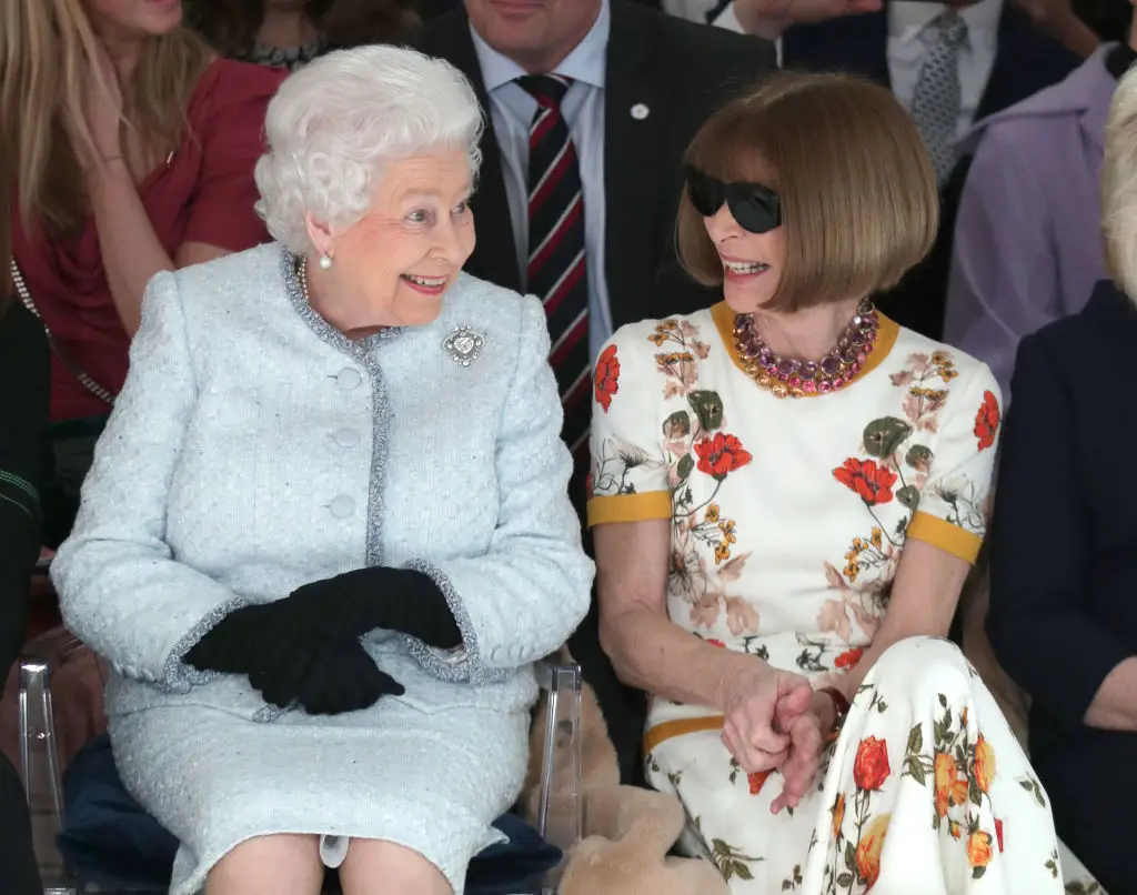 Wintour even wore the shades whilst sat next to Queen Elizabeth during a runway event (WPA Pool / Pool / Getty Images)