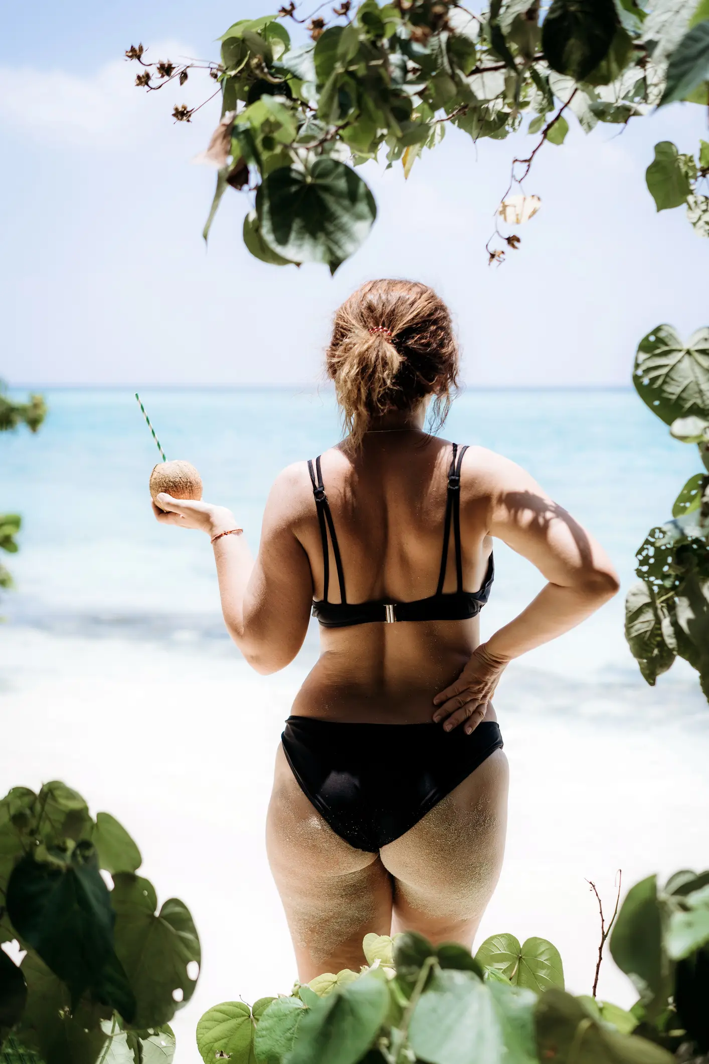 Middle age woman standing on the sandy beach by the ocean (Fiordaliso/Getty Images))