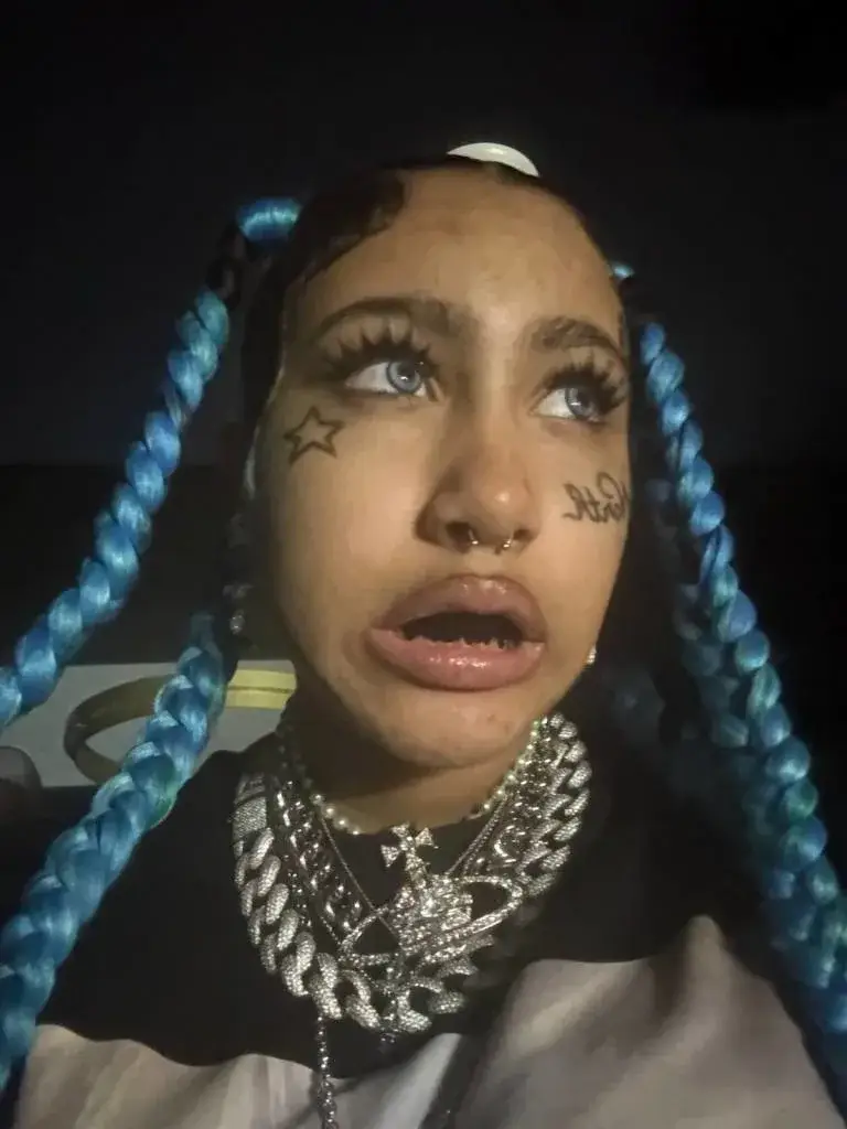 She sported blue braids, eye contacts, what looks like fake lashes, and faux face tattoos and piercings (TikTok/@kimandnorth)