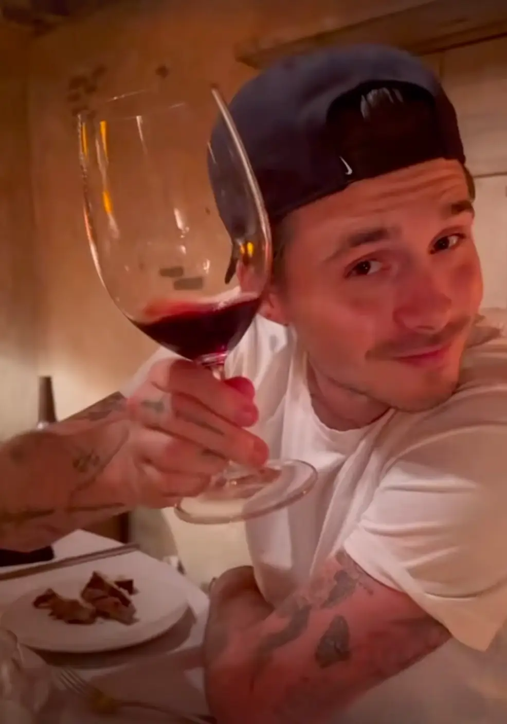 Brooklyn was seen drinking wine and enjoying food in the clip (Instagram/@nicolaannepeltzbeckham)