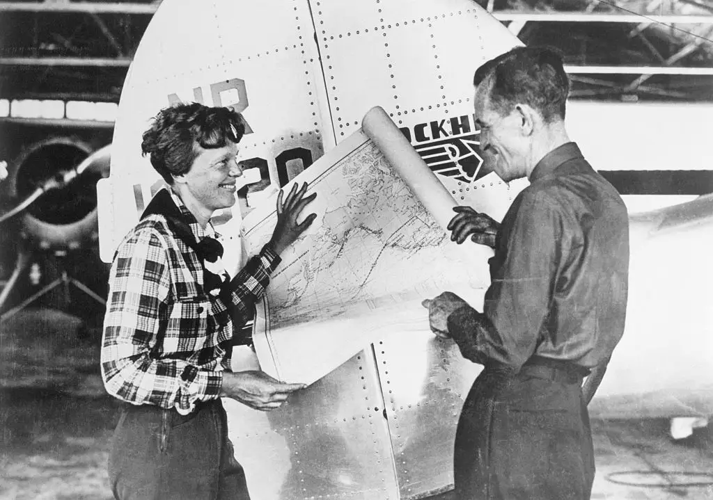 Pilot Amelia Earhart and her navigator, Fred Noonan, with a map of the Pacific (Bettmann / Getty Contributor)