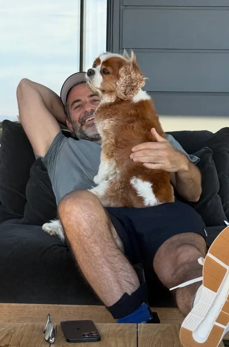 She included a photo of him cuddling up to a cavalier King Charles Spaniel (Instagram/jenniferaniston)