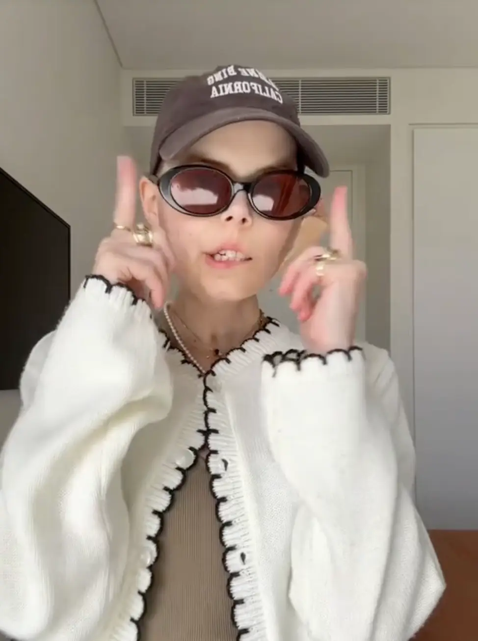 Bella styled out a khaki dress and a white cardigan, among other accessories for her final 'get ready with me' video (TikTok/@bellabradford0)