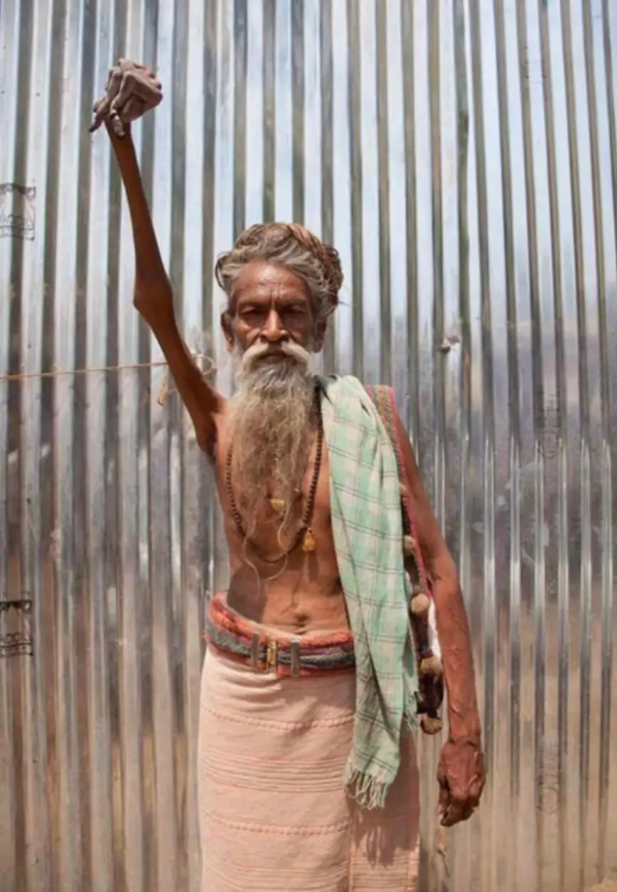 The man has had his right hand in the air for 50 years. (X)