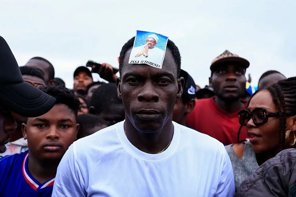 A supporter wearing a photograph of Bakary at a rally earlier this month (DANIEL BELOUMOU OLOMO/AFP via Getty Images)