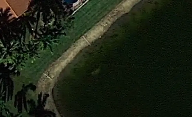 The submerged car is barely visible beneath the water. (