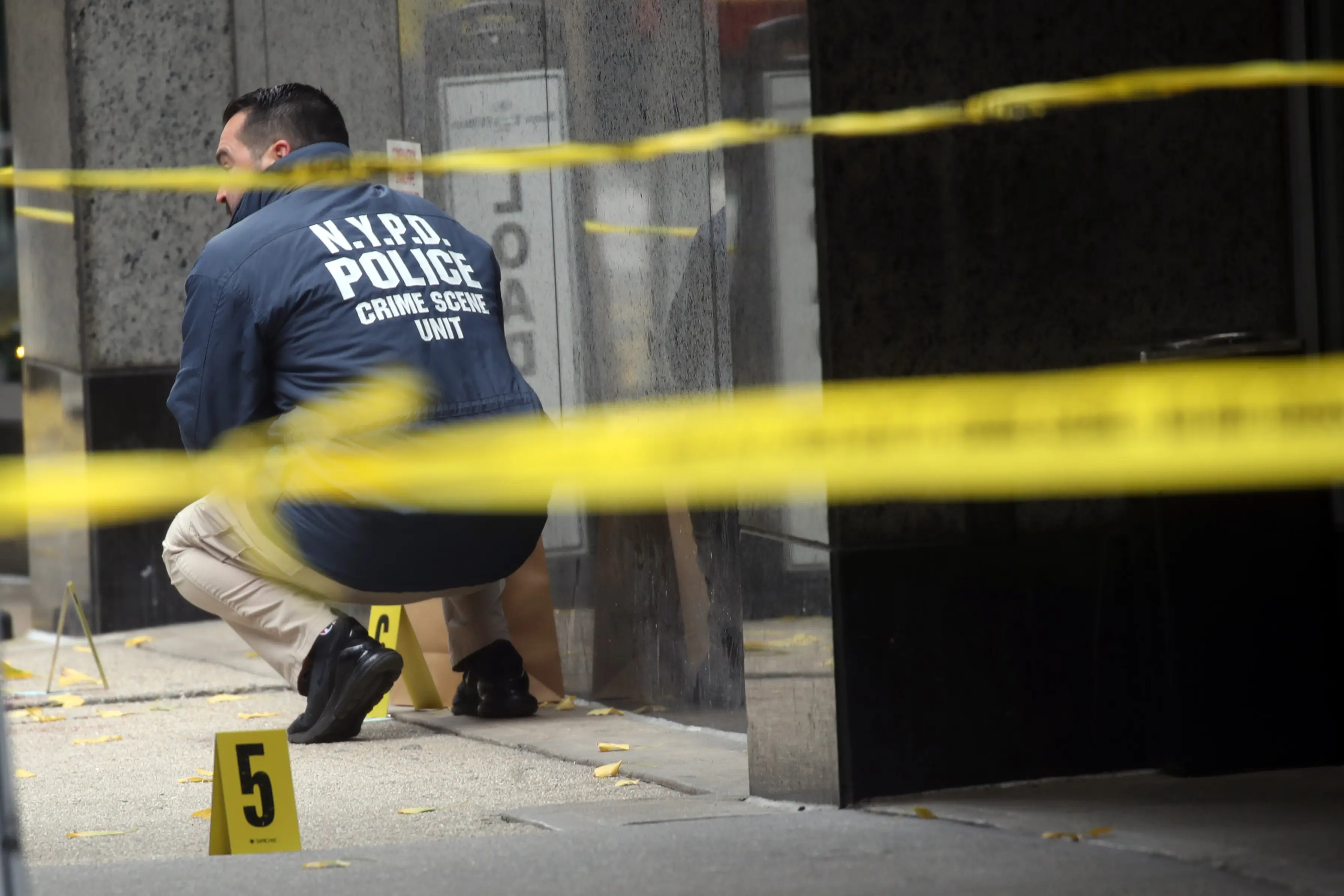 Police placing bullet casing markers outside of a Hilton Hotel where Thompson was killed (Spencer Platt/Getty Images)