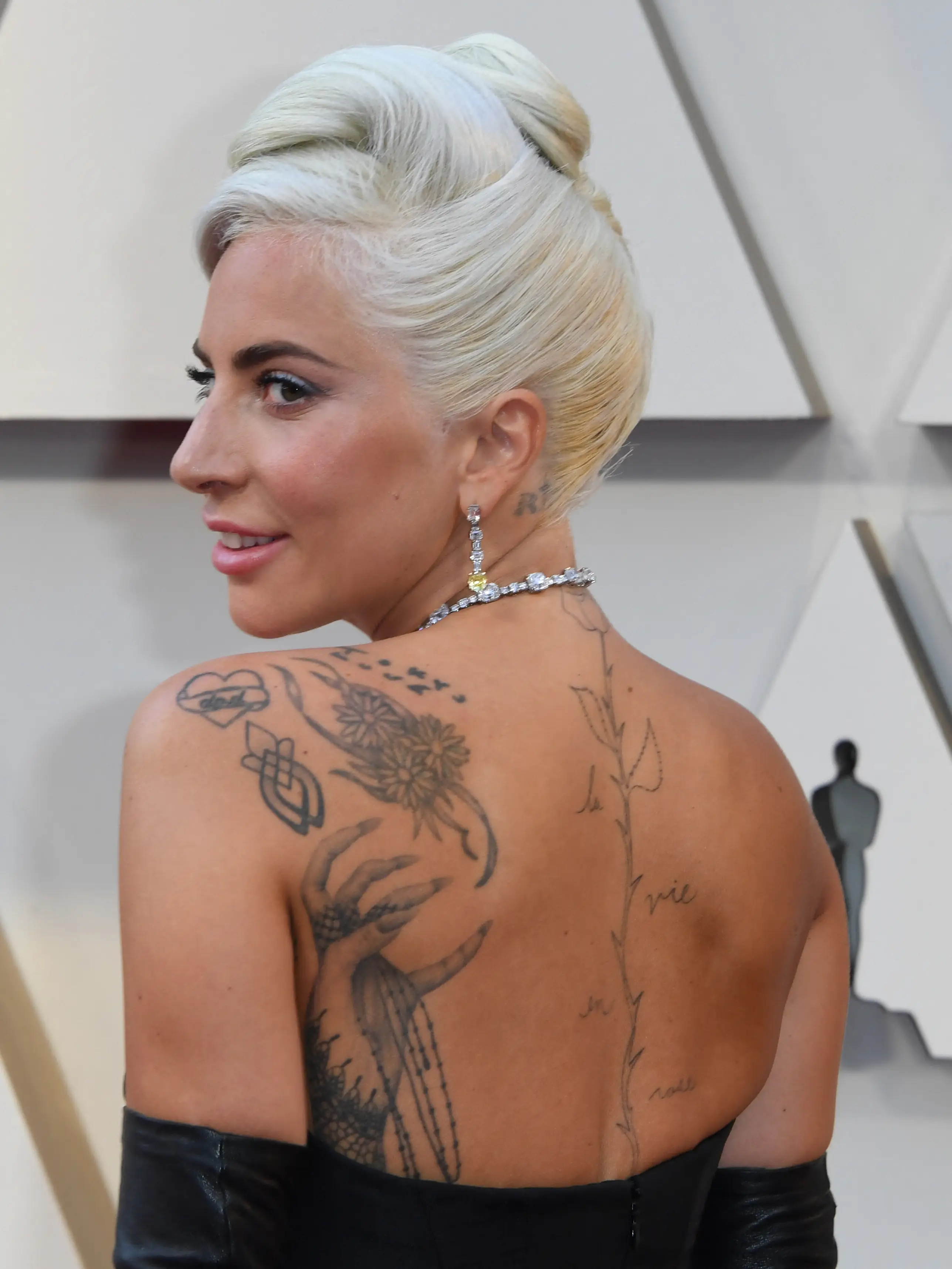 Gaga has a large tattoo of a single rose going down her spine (MARK RALSTON/AFP via Getty Images)