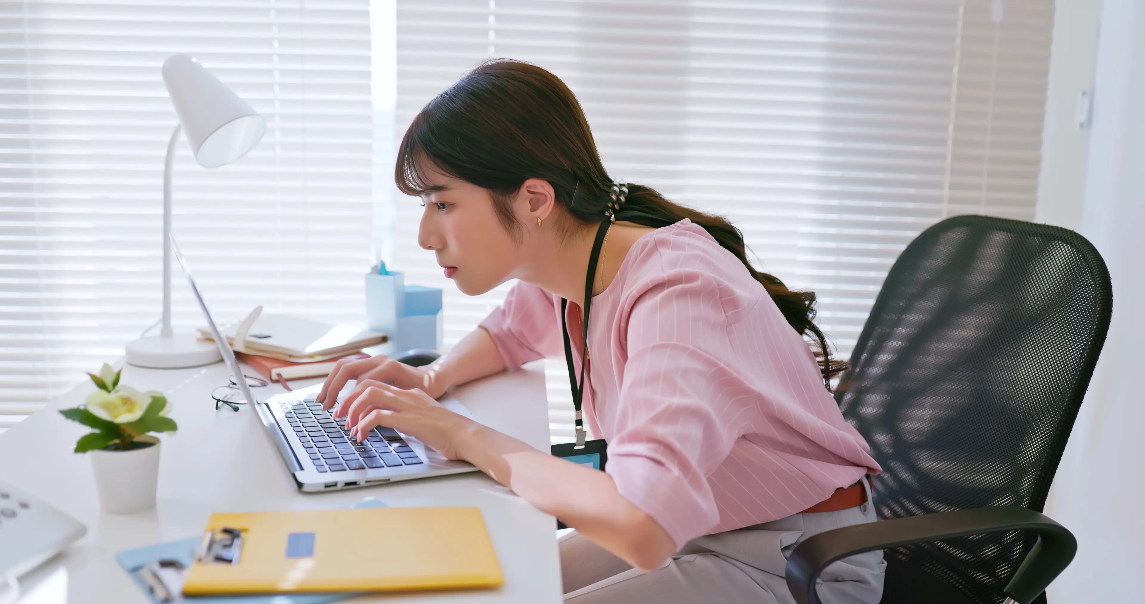 Bad posture like hunching over a laptop can cause things like back pain over time (PonyWang/Getty)