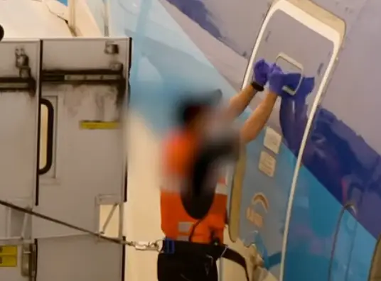 The airport worker banged on the door to make sure it was sealed. (YouTube/Fairport)