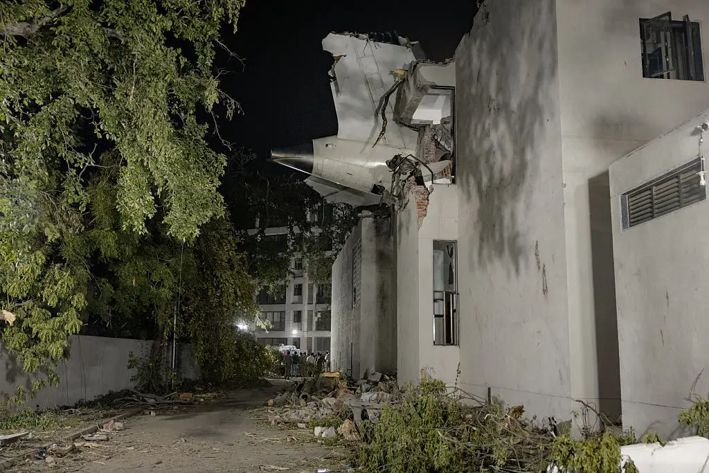 The tail of the airplane sticks out of a medical college hostel after the Air India commercial plane crashed shortly after take-off on June 12 (Elke Scholiers/Getty Images)