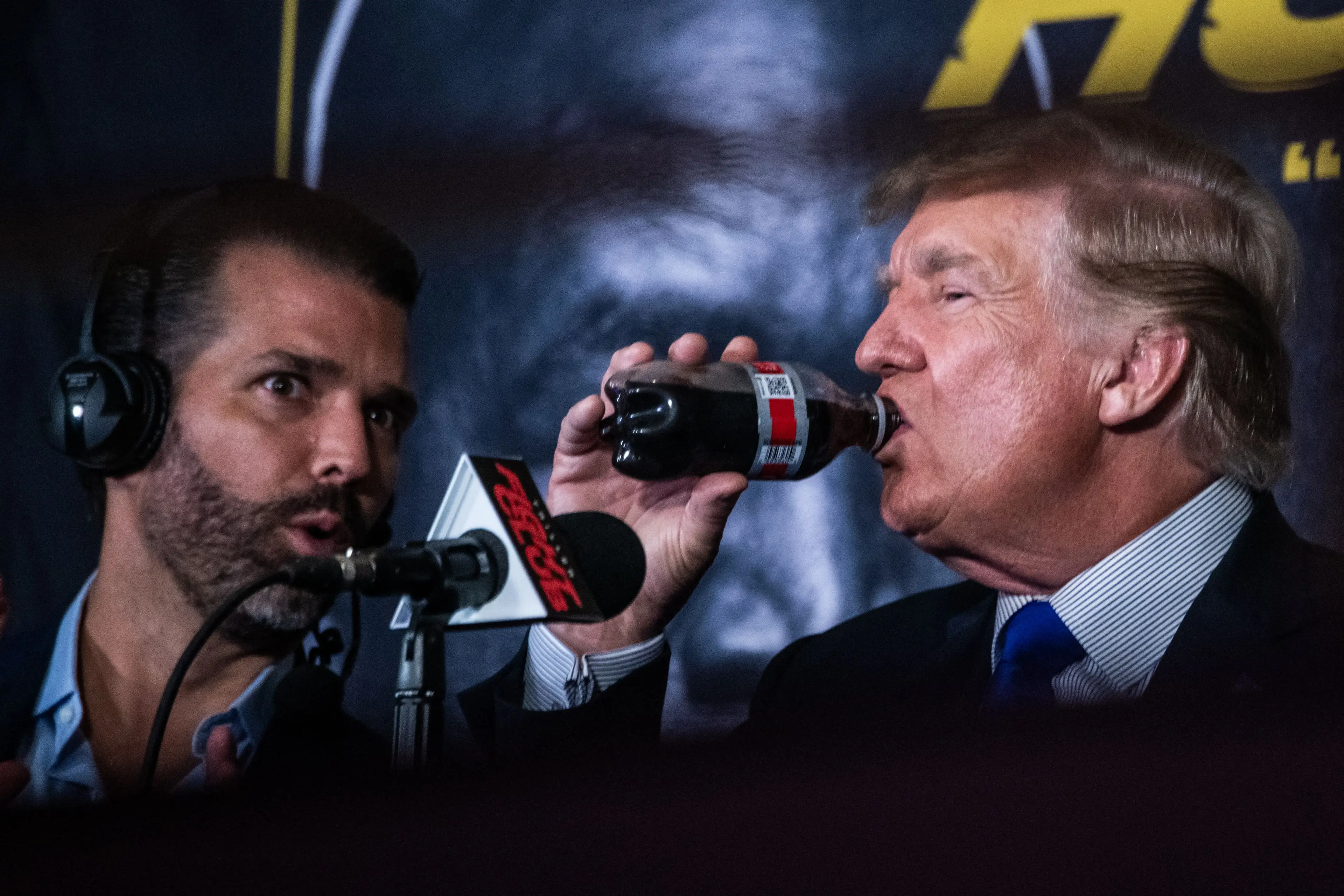 Donald Trump swigs a diet soda while at a boxing event in 2021 with son Donald Trump Jr (CHANDAN KHANNA/AFP via Getty Image)