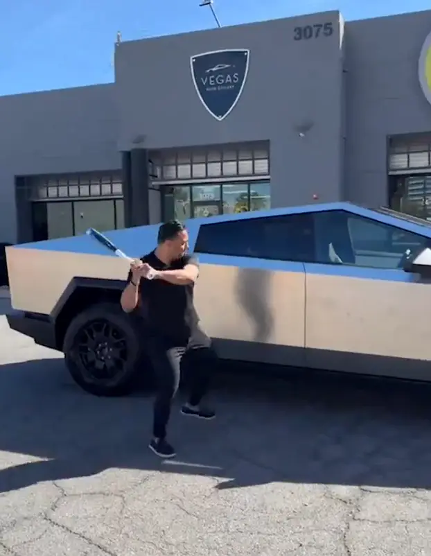 The footage shows a bunch of people taking a baseball bat to a Cybertruck.