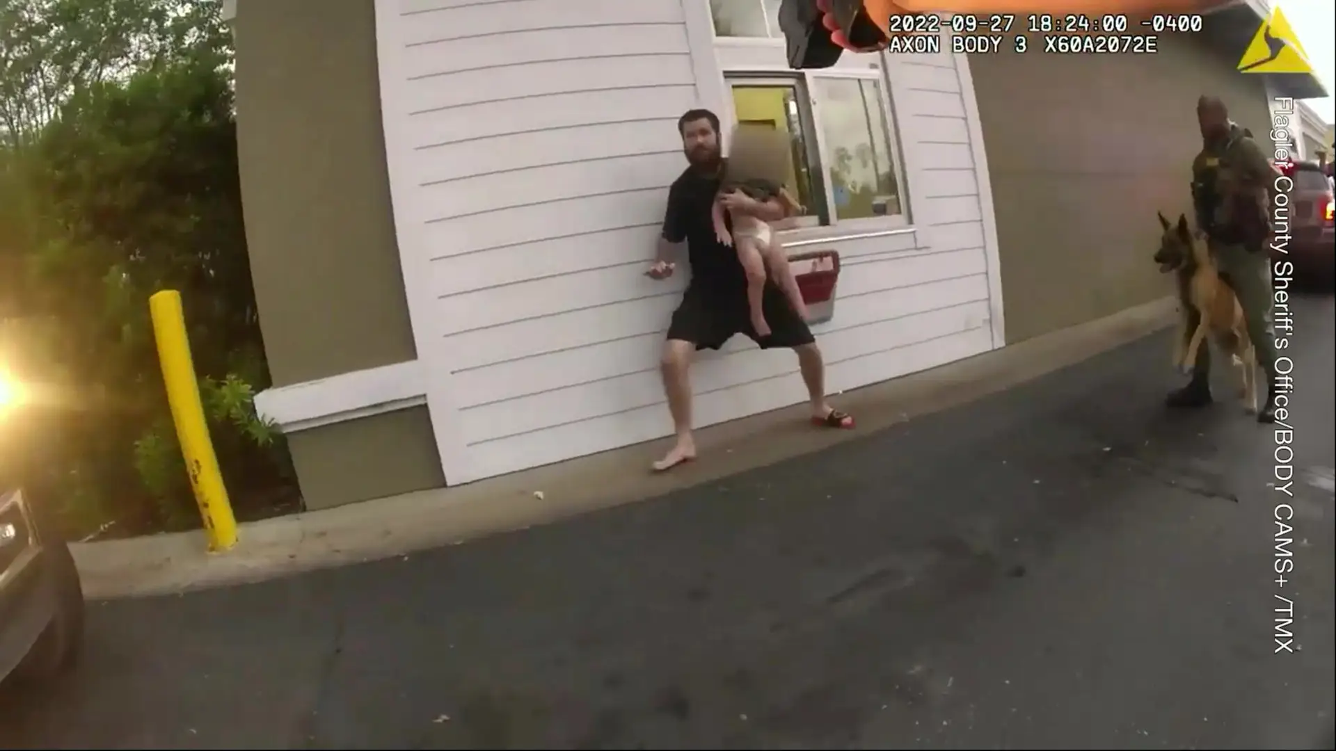 Brandon Matthew Douglas Leohner, 27, is seen holding the infant at his chest while at a drive-thru fast food restaurant.