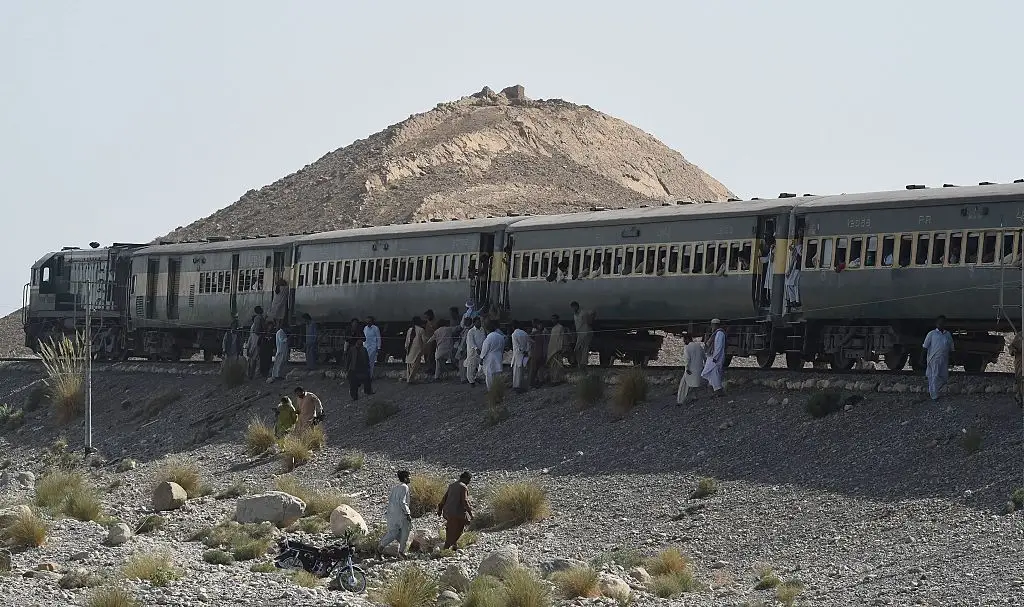 Pakistani passengers gather around a train following two explosions in the town of Much, 55 kilometres east of Balochistan's provincial capital Quetta, back in 2016 (BANARAS KHAN/AFP via Getty Images)