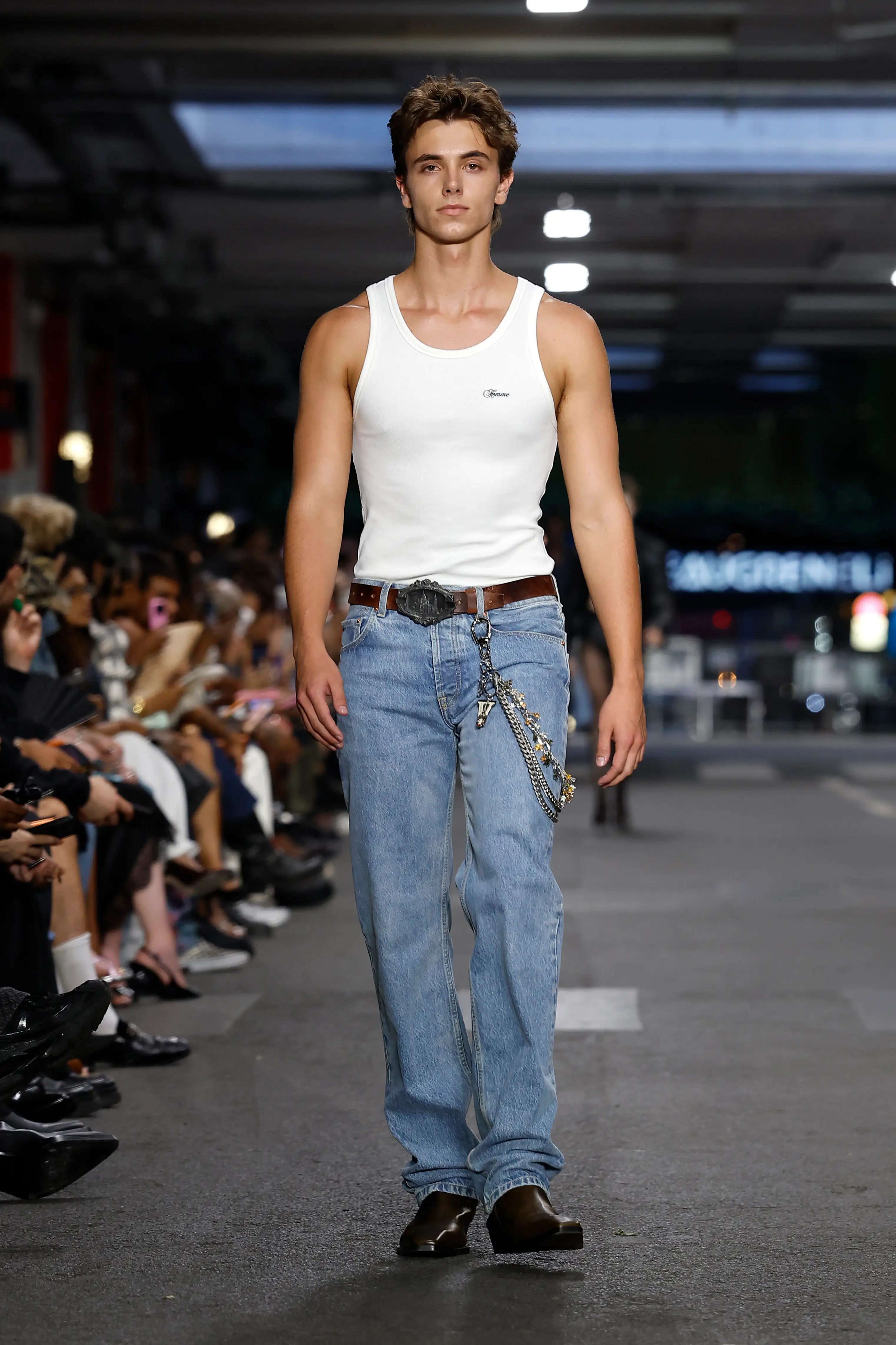 Jayden opted for a more casual look with faded blue jeans, a fitted white tank top and dark brown loafers, finished off with a leather belt and layered chains.(Photo by Estrop/Getty Images)