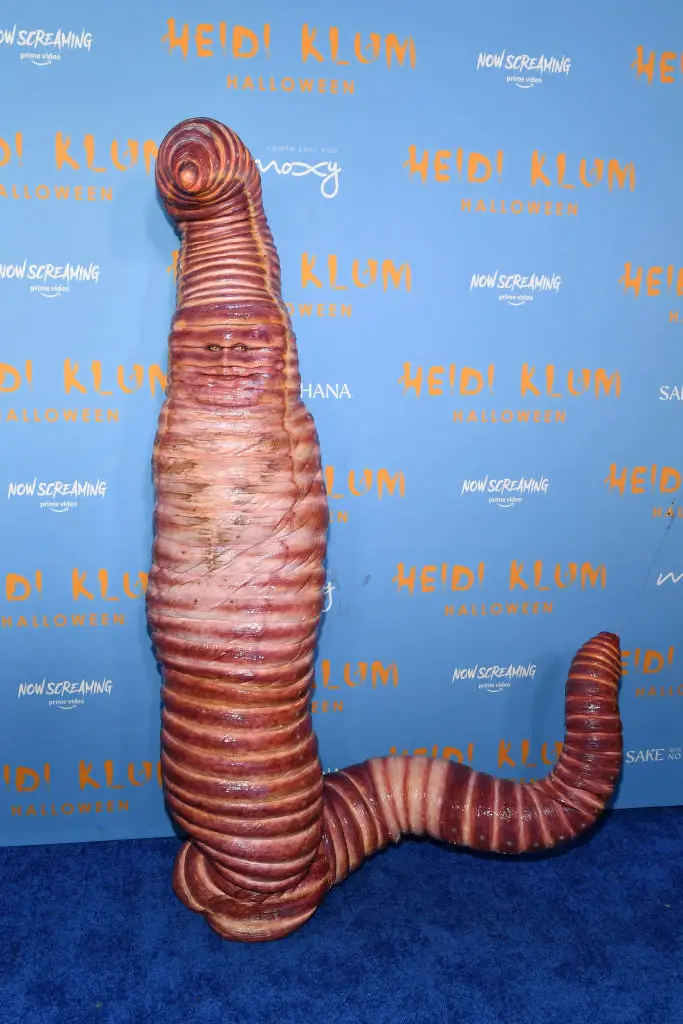 Klum dressed as a worm in 2022 and as a skinless human body in 2011.  (Photo by Noam Galai/Getty Images for Heidi Klum)