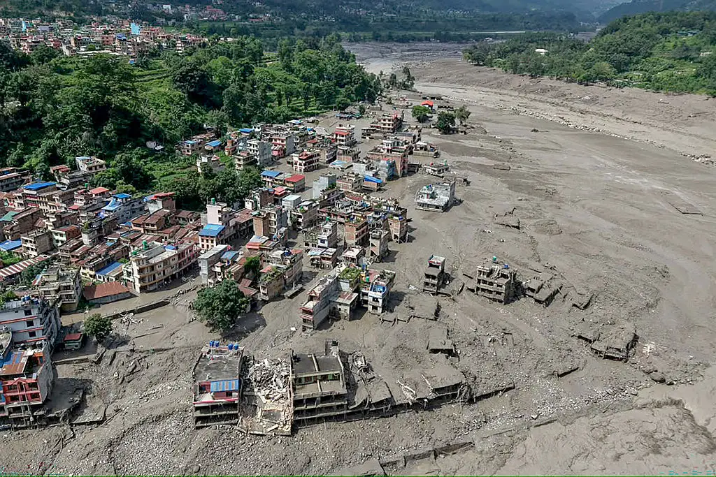 Houses lie partially submerged in muddy water along a riverside after flash floods at Trishuli Bazar in Nepal's Nuwakot district on August 26 (Prabin RANABHAT / AFP via Getty Images)
