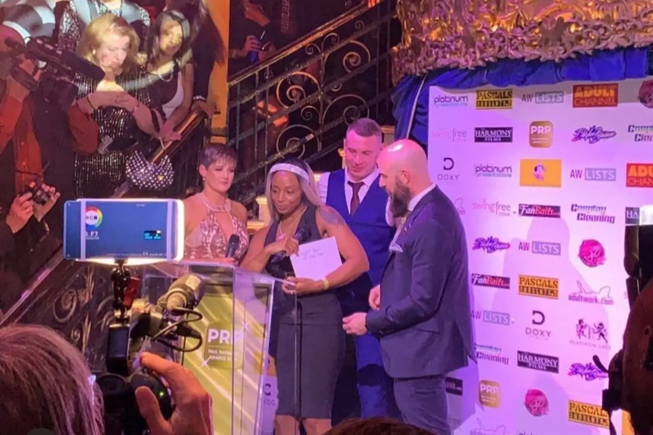 The influencer pictured in a blue waistcoat back in 2019 during his playboy years, presenting an award (SWNS)