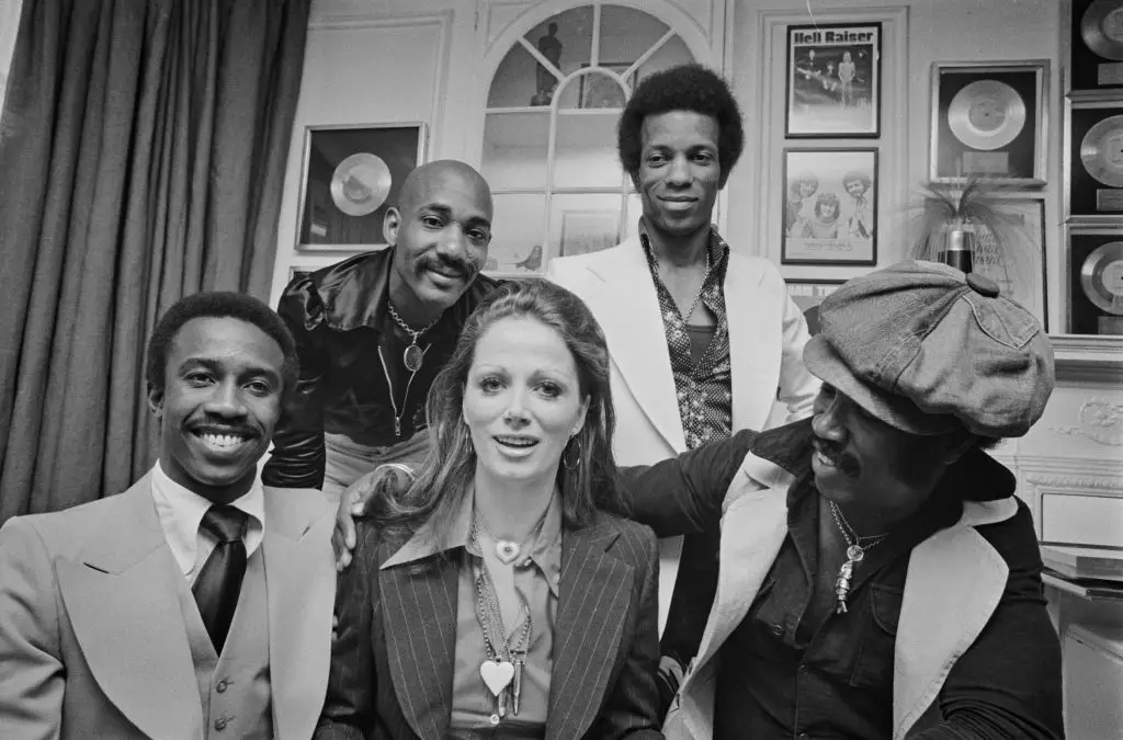 British soul band Hot Chocolate pose with English romance novelist Jackie Collins in 1974 - Tony is on the top right (Evening Standard / Hulton Archive /  Getty Images)