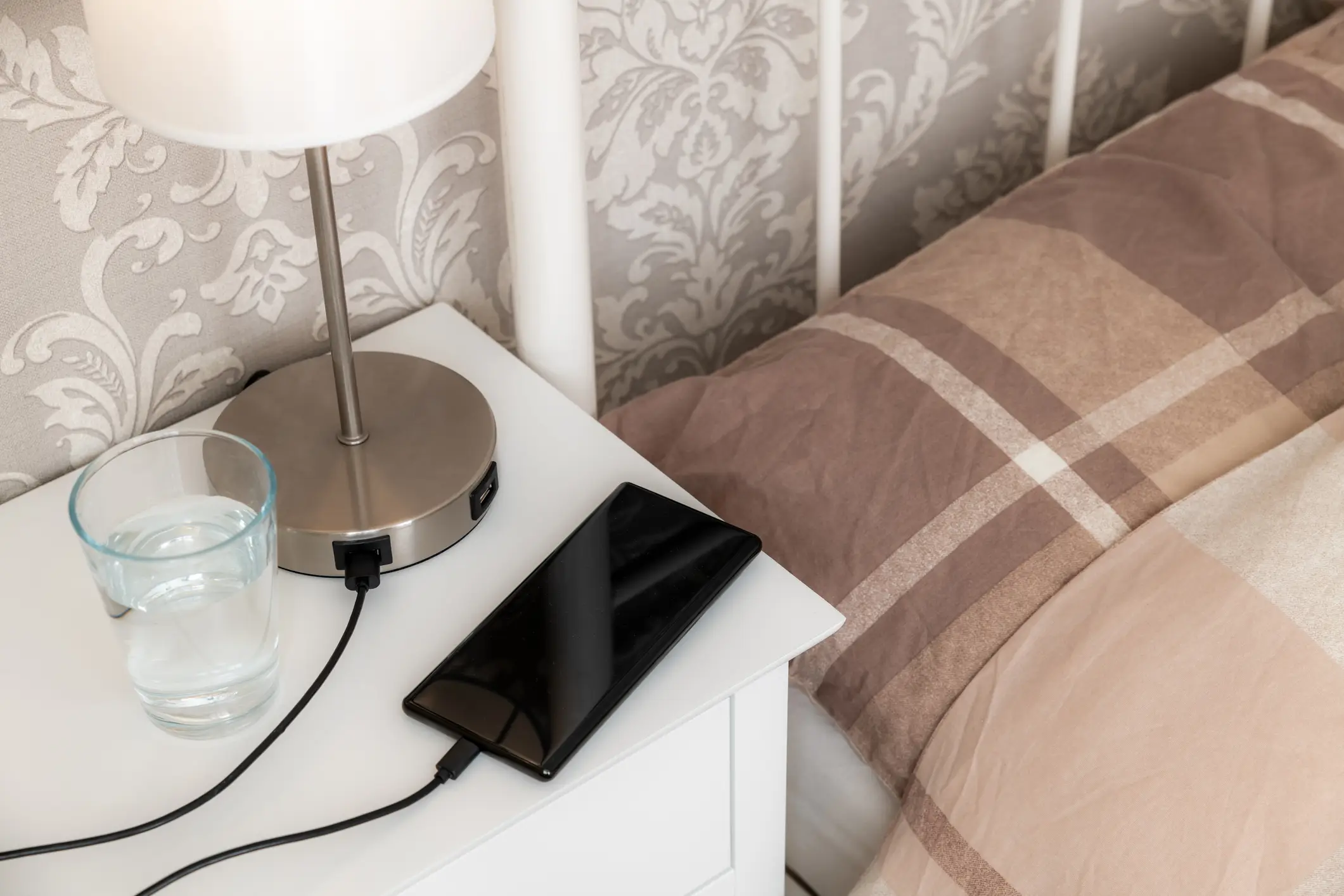 Fire safety experts say that phones should be charged on hard surfaces, such as a bedside table (Getty Stock)