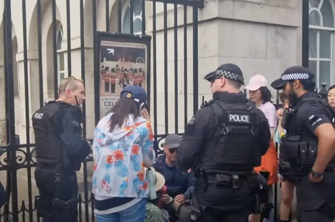 Armed officers gathered around the woman after she fainted. (YouTube/@busk1976)