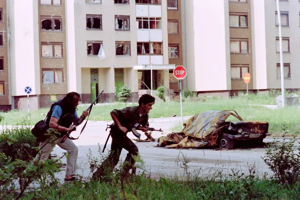 Bosnian soldiers running for cover from Serb fire in Sarajevo, July, 1992 (PASCAL GUYOT/AFP via Getty Images)