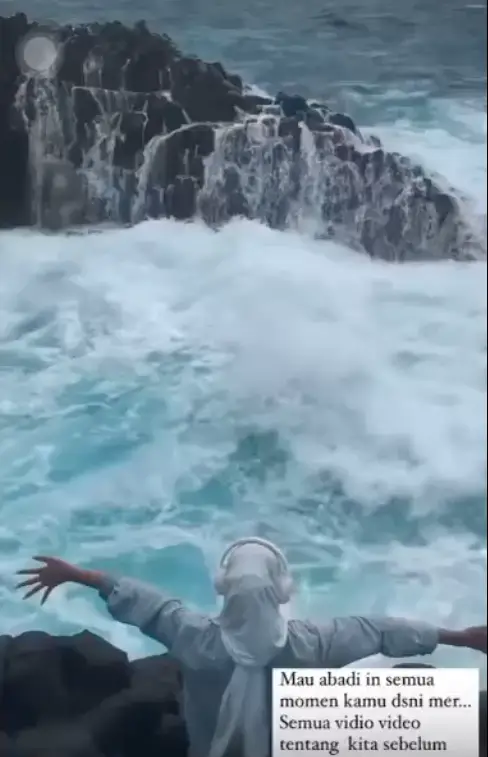 She posed with her arms open towards the waves (@baiqrosdiani/TikTok)