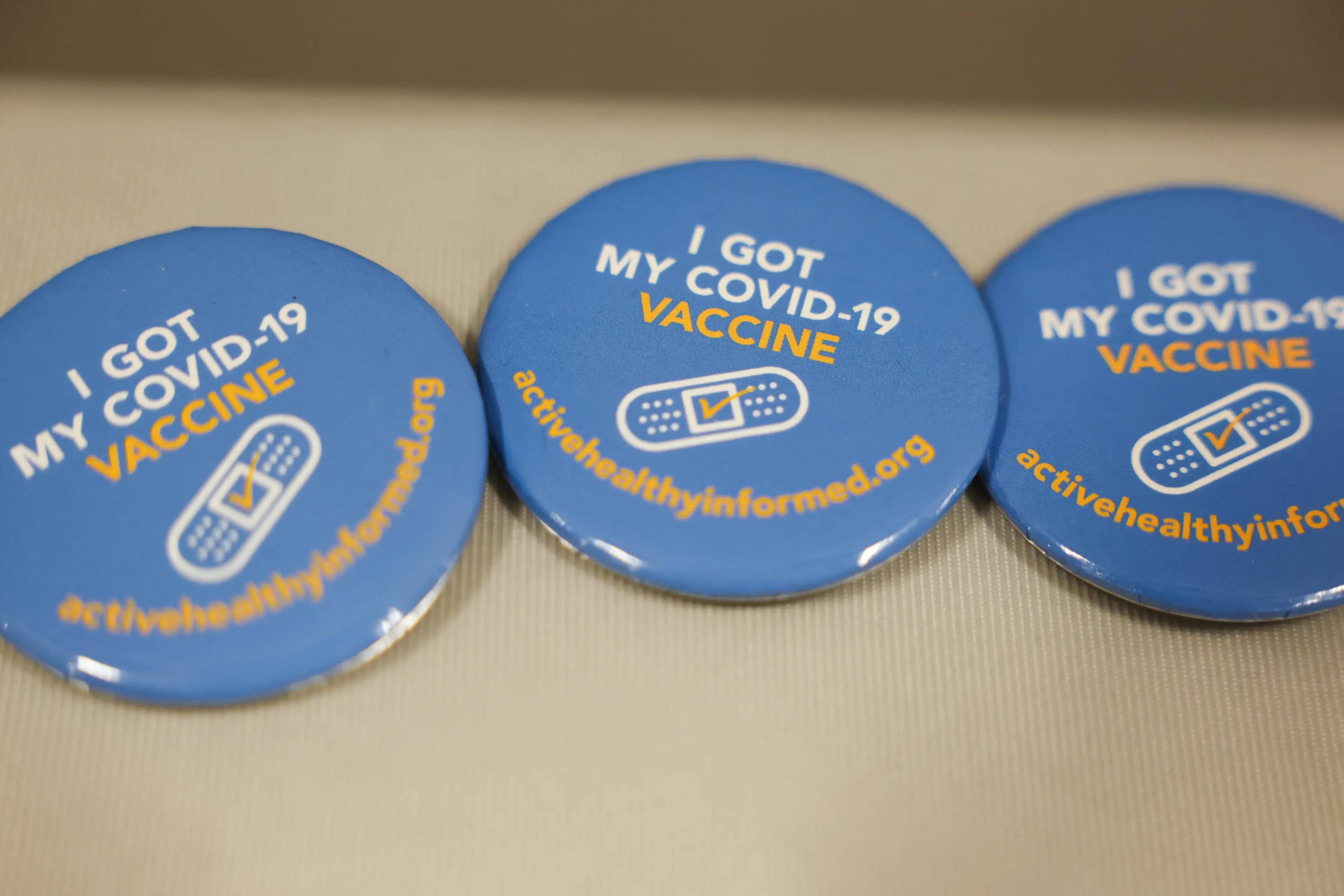 You get more than just a snazzy badge from taking the vaccine (PATRICK T. FALLON/AFP via Getty Images)