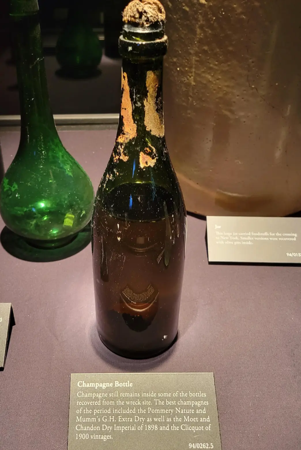 A champagne bottle recovered from the Titanic wreck on display in a museum (Reddit)